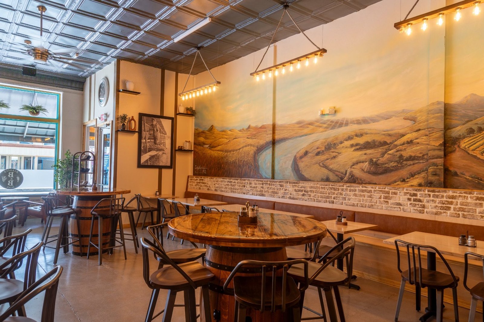 Warm Barrels & Bean interior with Arizona mural and barrel tables
